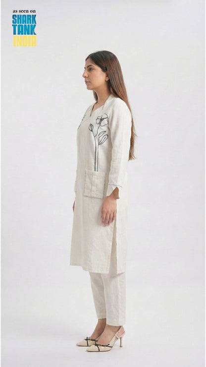 Woman wearing a white outfit with a floral design on a white background
