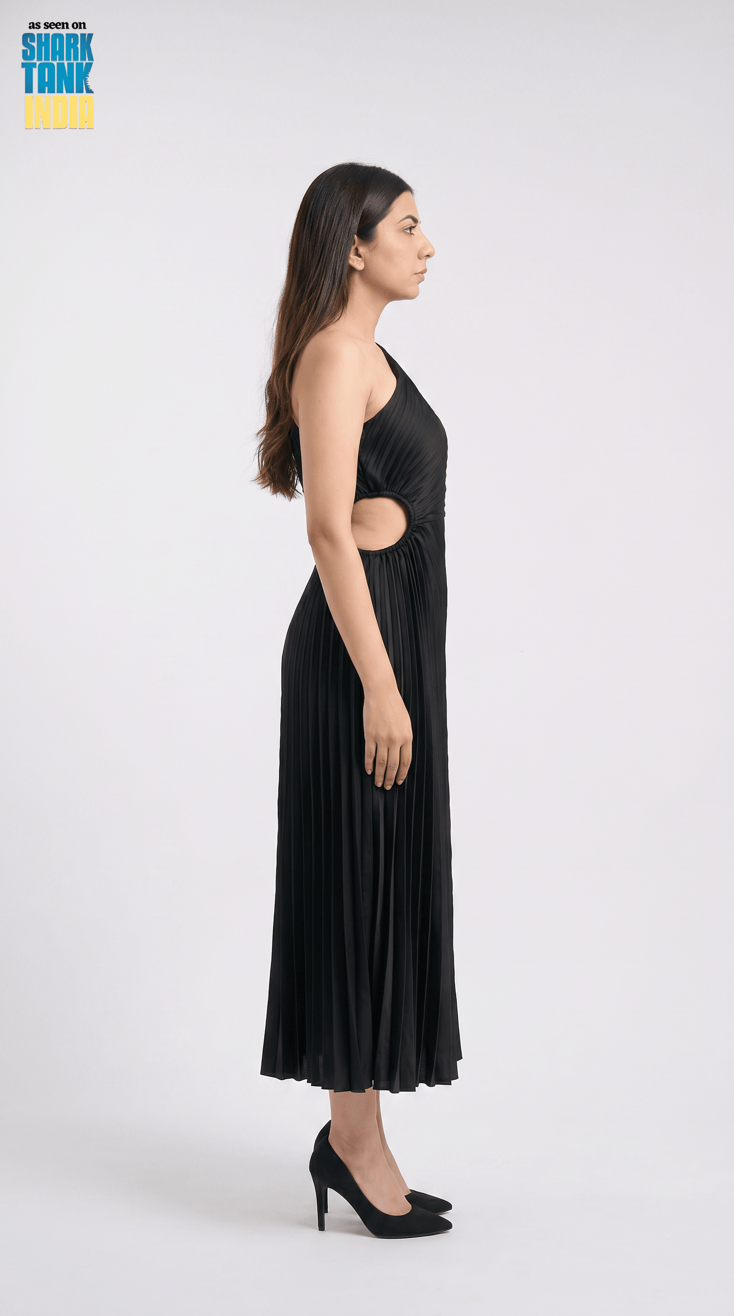Woman wearing a black dress with cut-out design on a white background