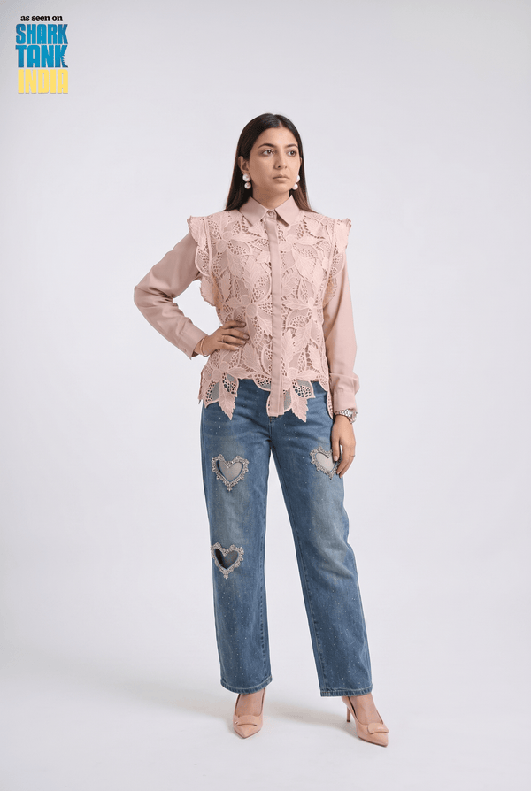Woman wearing a pink lace blouse and blue jeans on a white background with 'Shark Tank' branding.