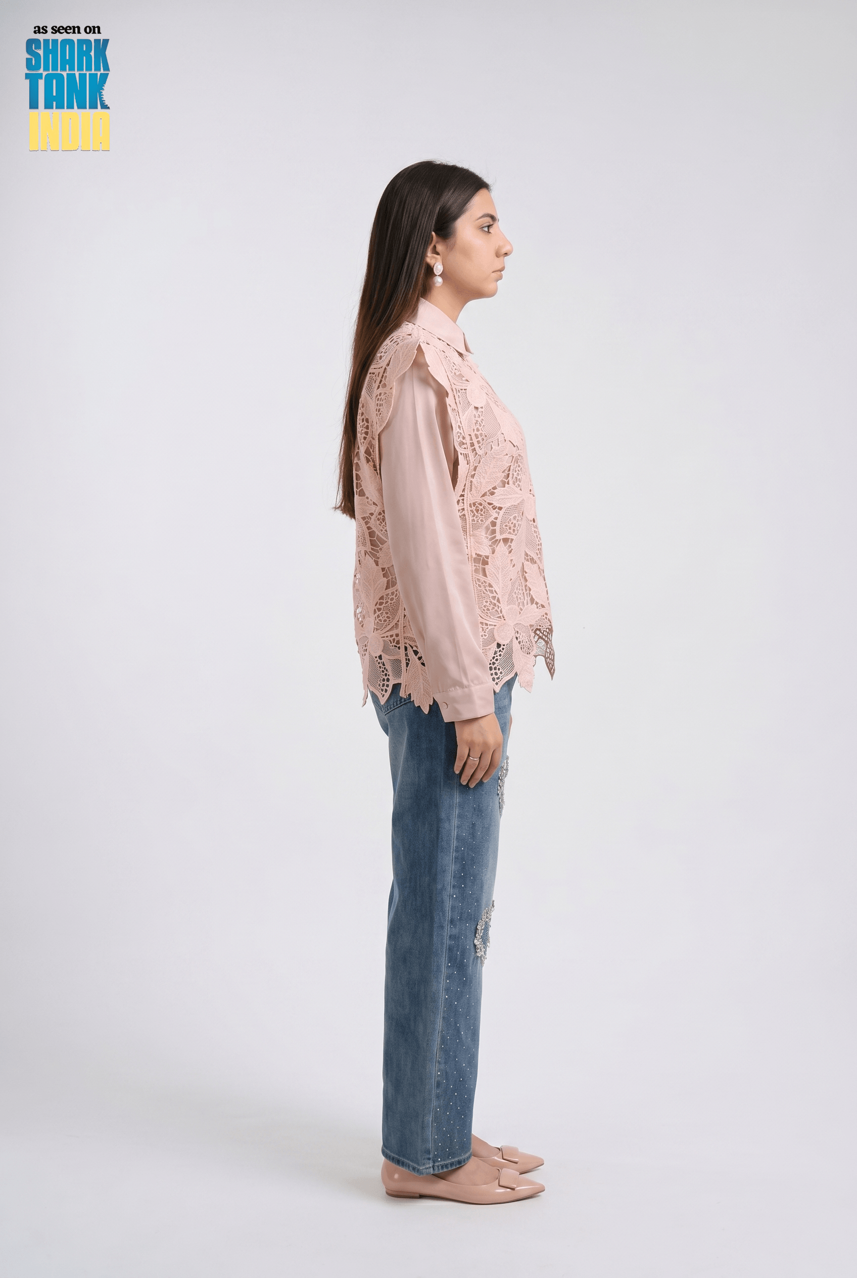Woman wearing a pink lace blouse and blue jeans on a white background with 'Shark Tank' branding.
