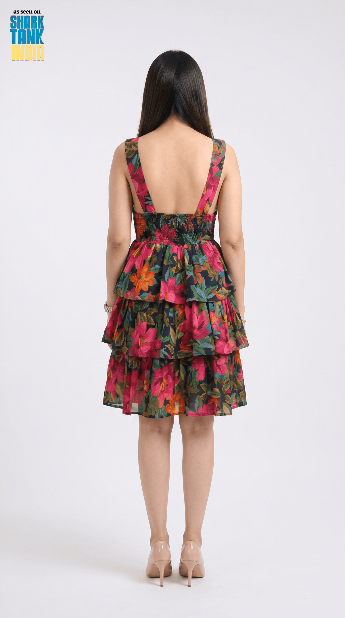 Woman wearing a colorful floral dress with a white background