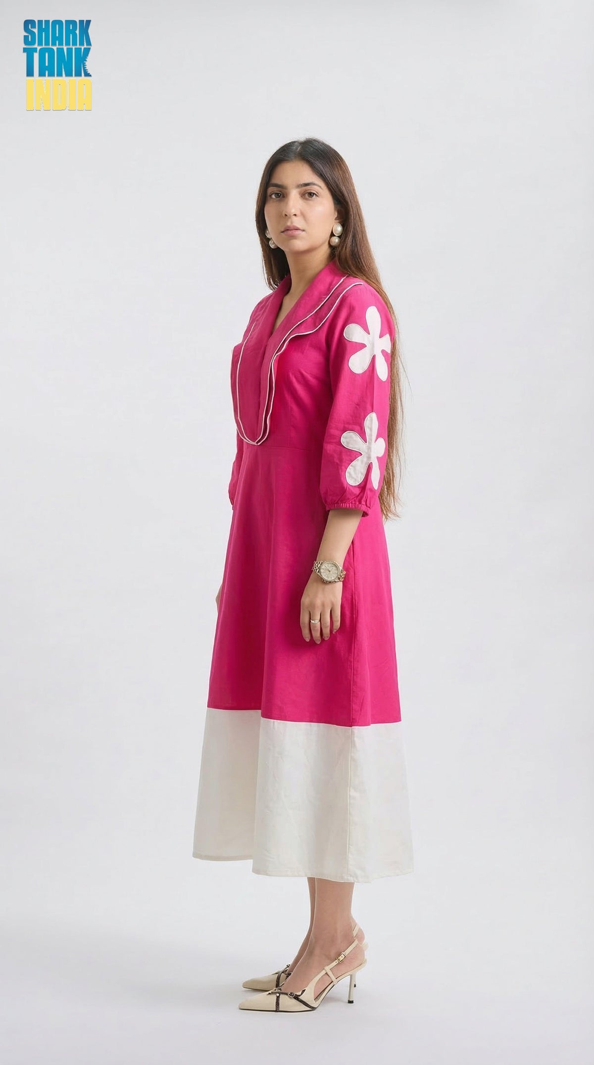 Woman wearing a pink dress with floral patterns on a white background