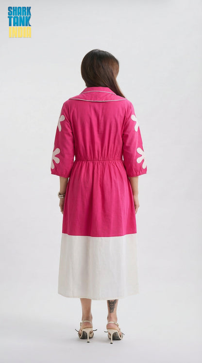 Person wearing a pink dress with white patterns on a white background