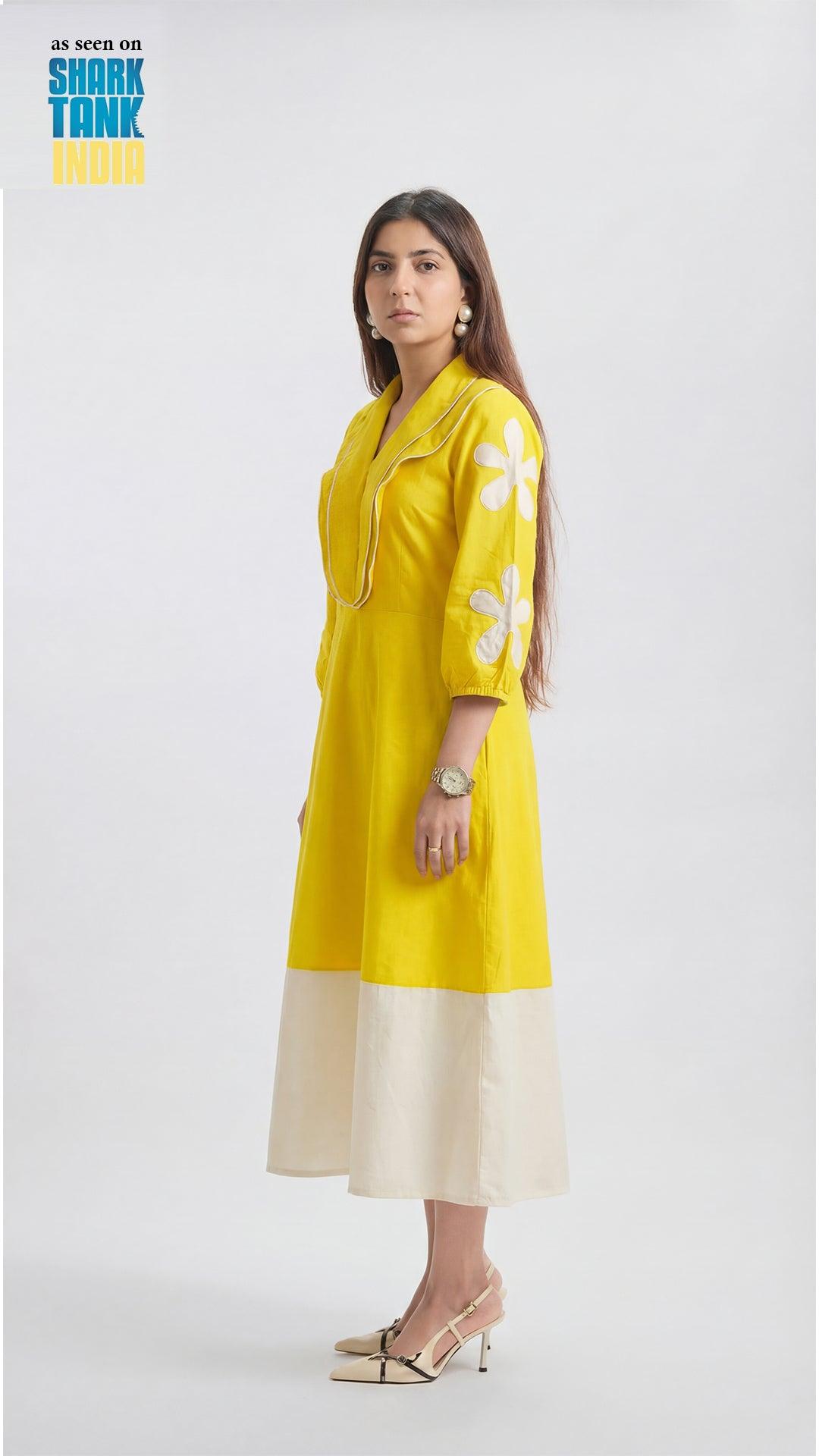 Woman wearing a yellow dress with floral patterns on a white background
