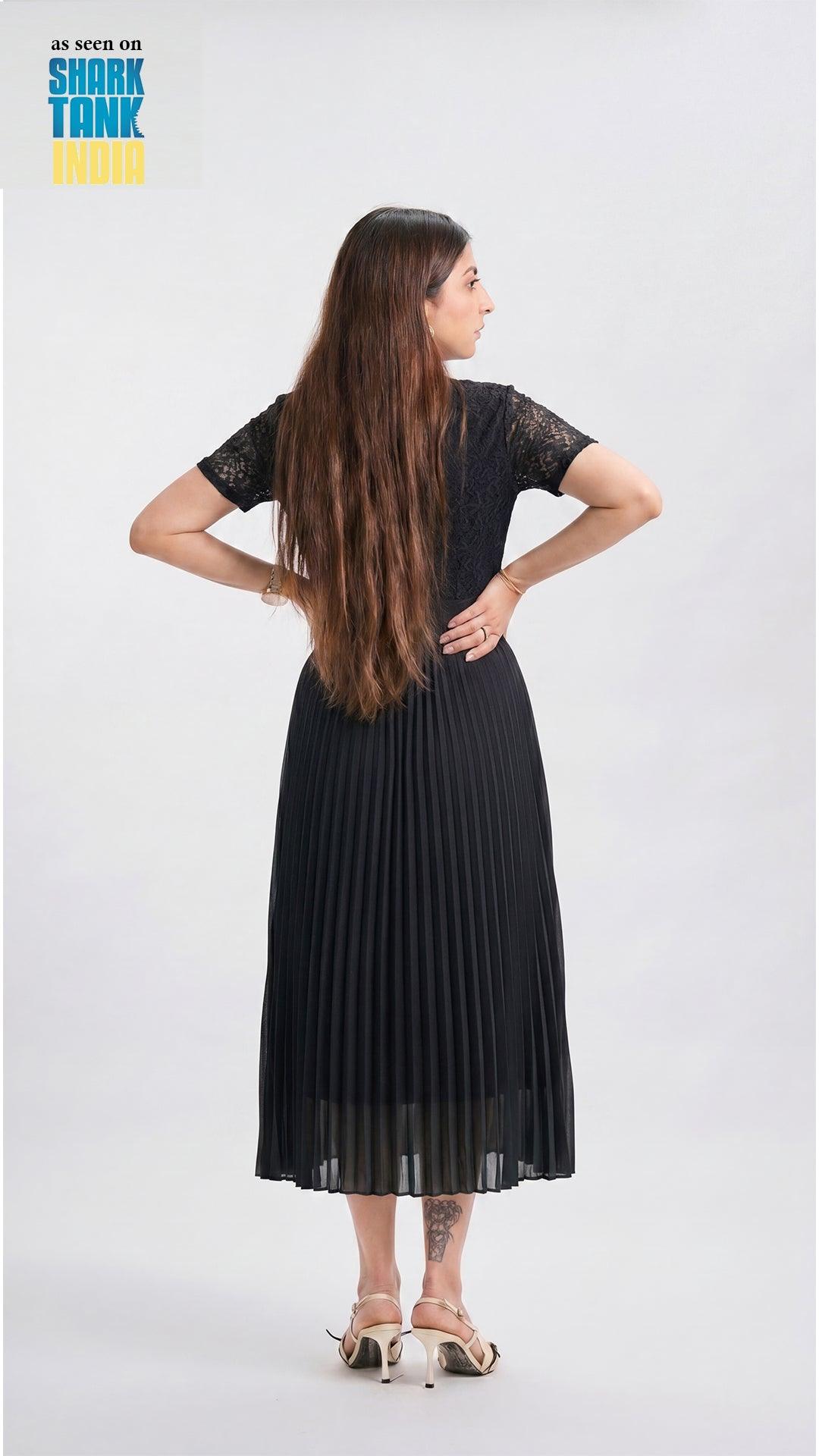 Woman wearing a black pleated dress on a white background