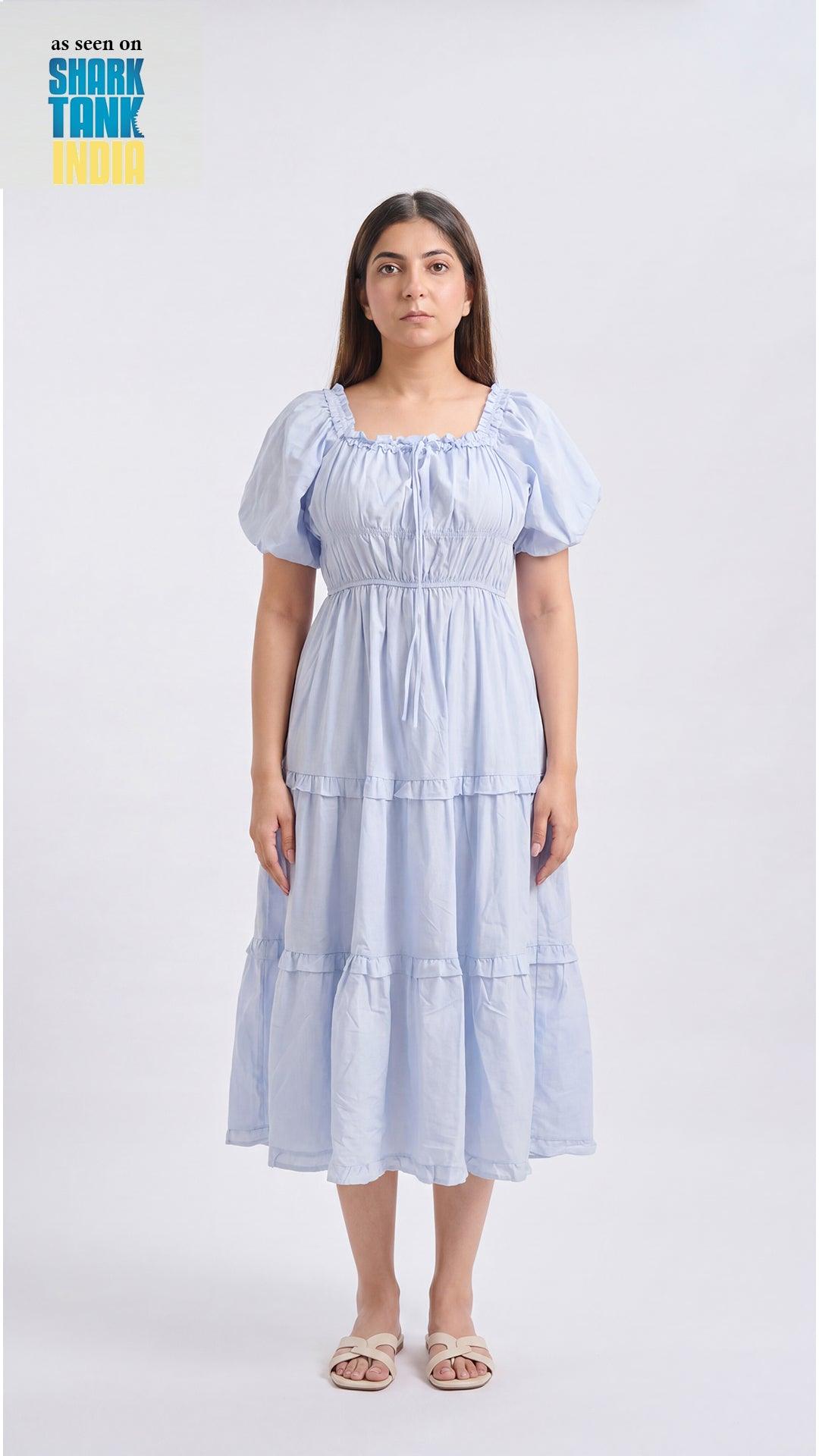 Woman wearing a light blue tiered dress on a white background with 'Shark Tank' branding.