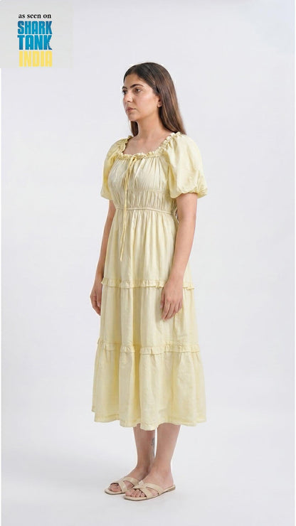 Woman wearing a yellow dress on a white background with 'Shark Tank' branding.