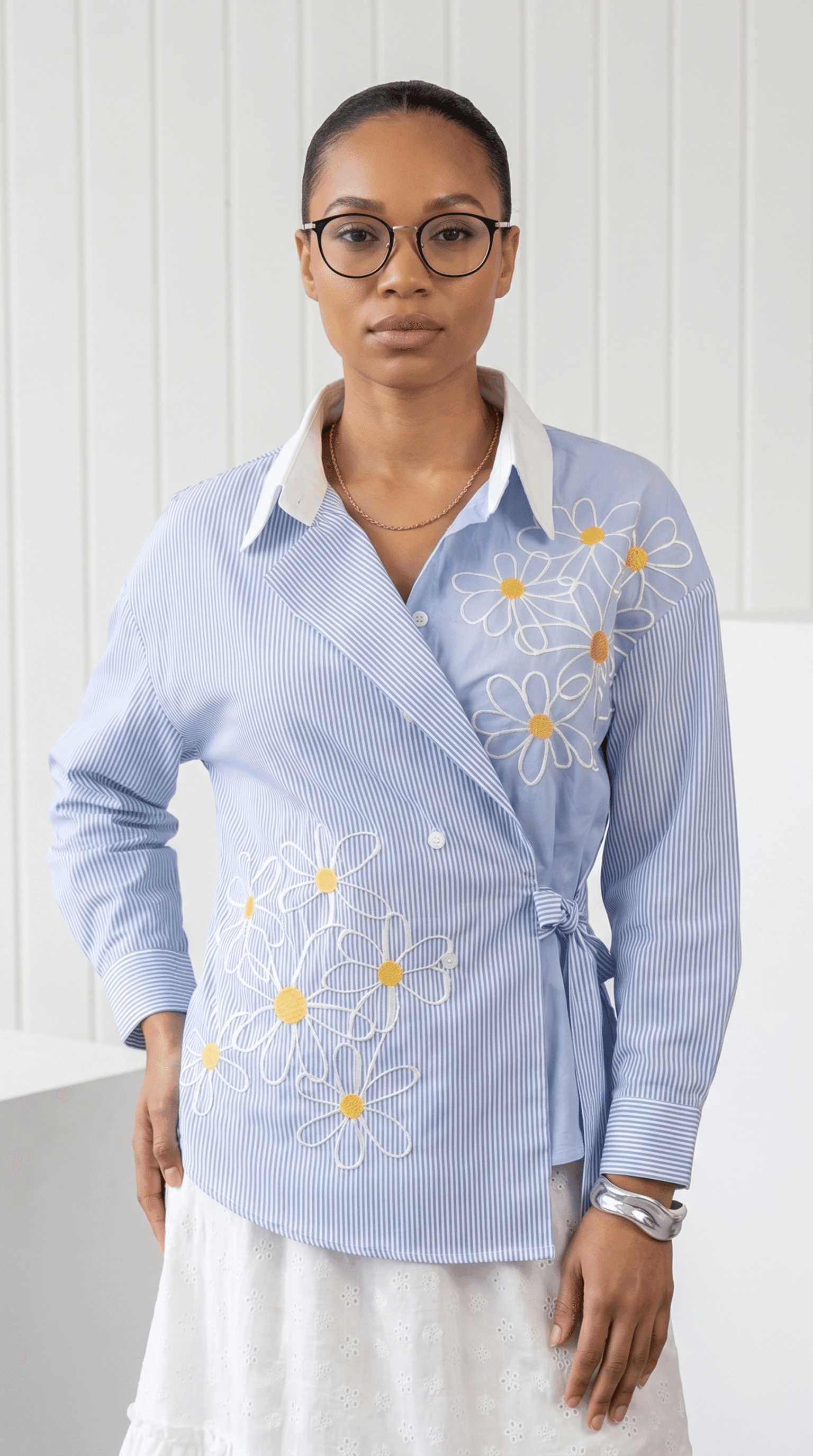 Woman wearing a light blue shirt with floral embroidery on a white background