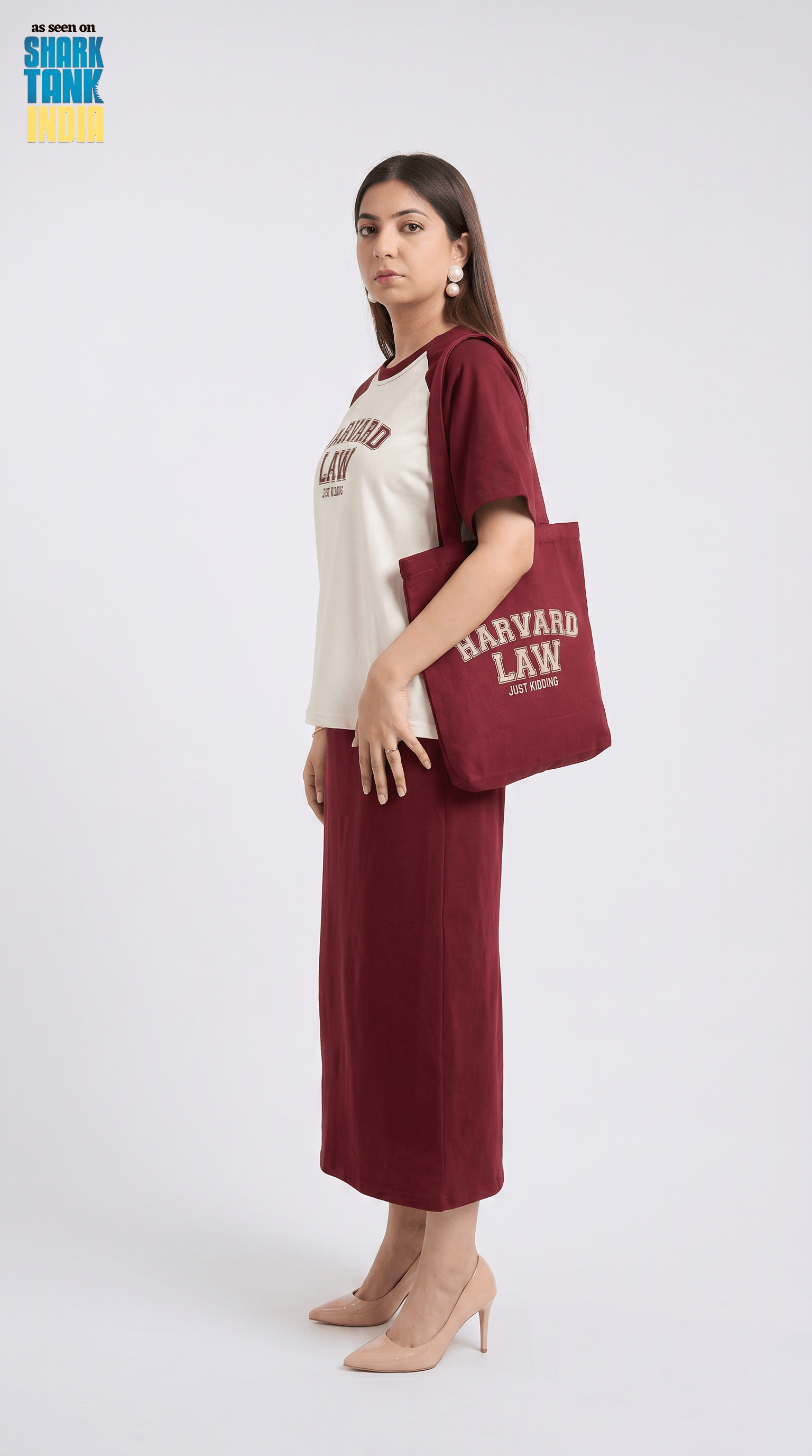 Woman holding a tote bag with 'Harvard Law' text on a white background