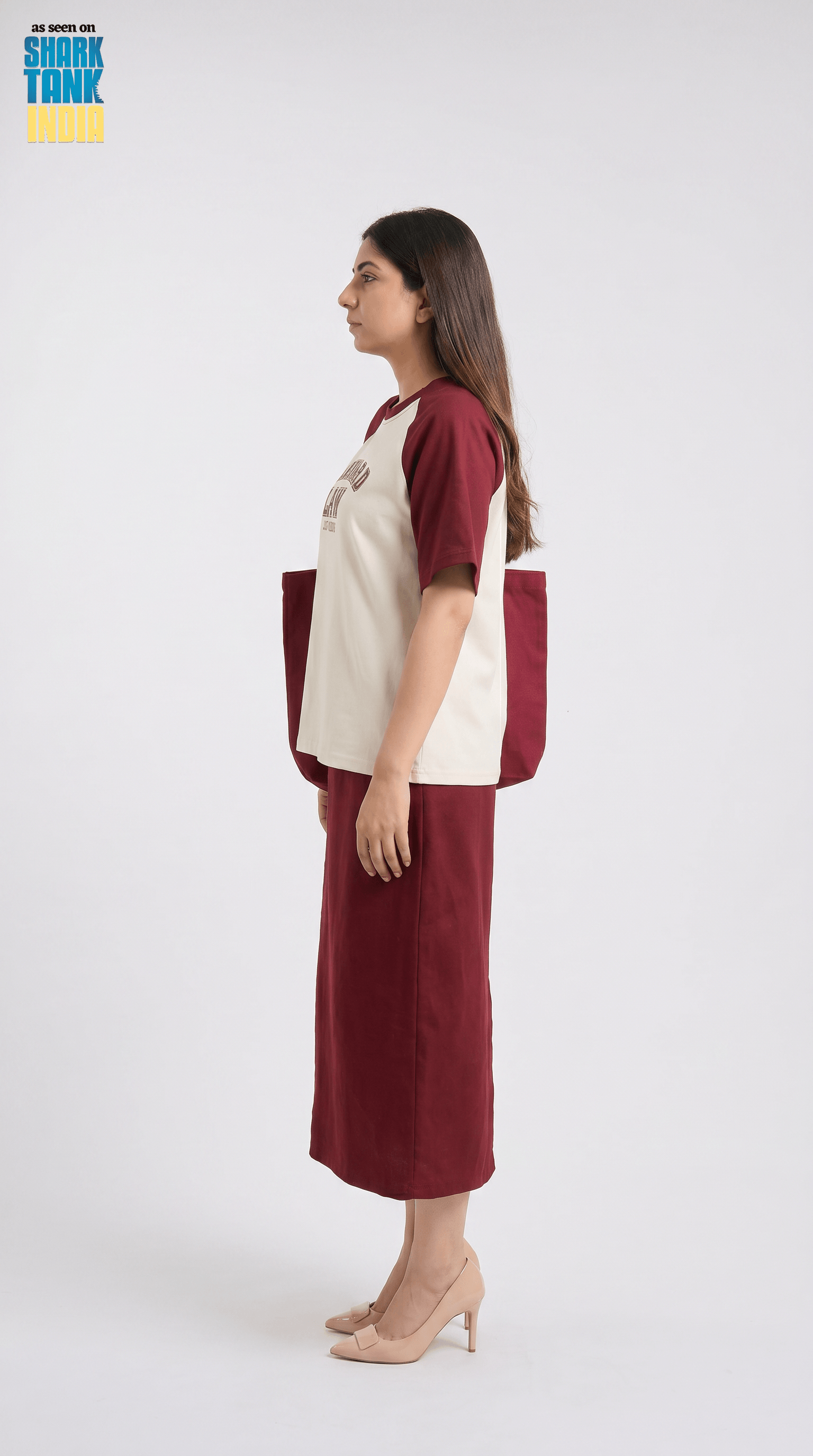 Woman wearing a maroon and beige outfit with a white background