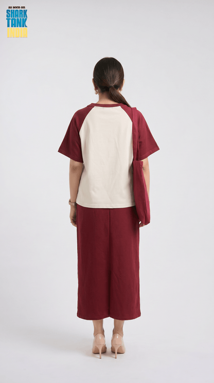 Woman wearing a maroon and beige outfit on a white background