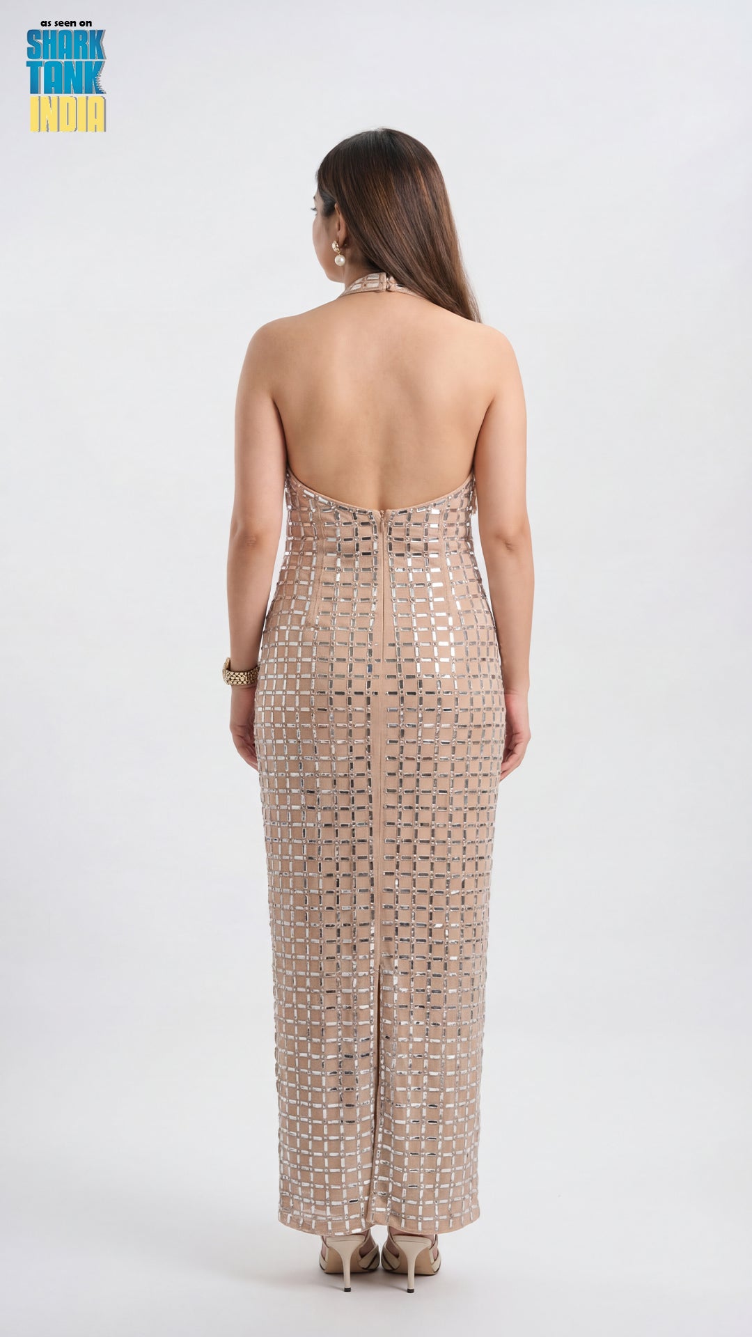 Woman wearing a strapless, patterned dress on a white background