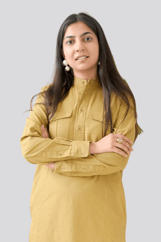 Woman wearing a mustard yellow shirt against a plain background