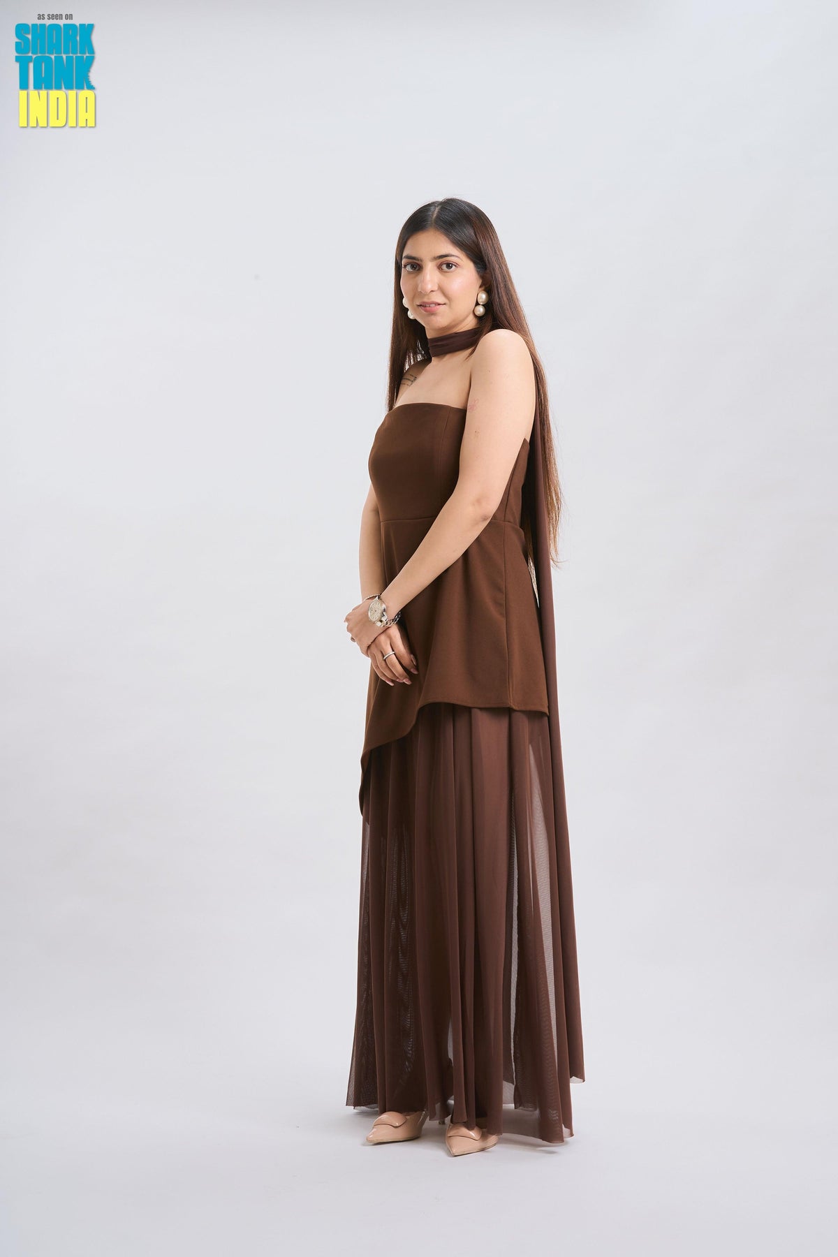 Woman wearing a brown dress against a white background