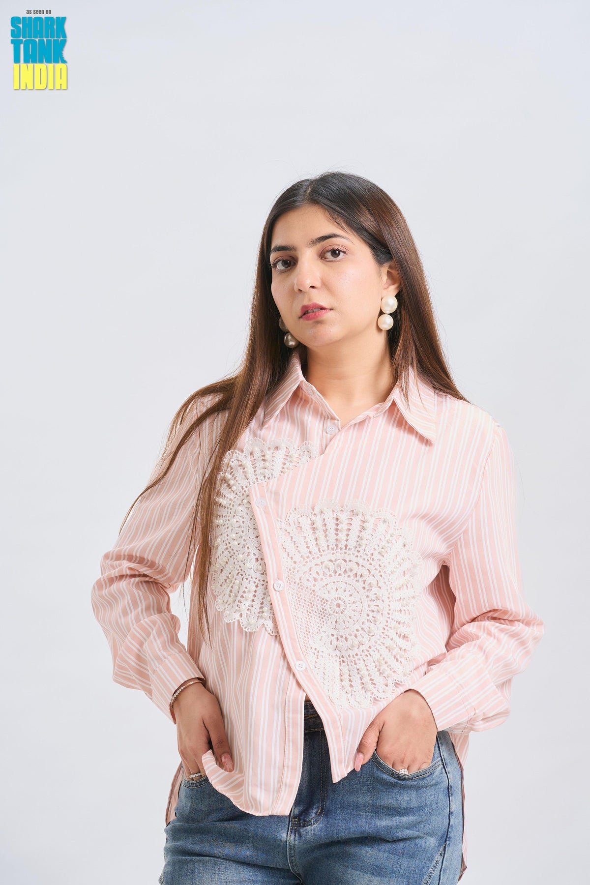 Woman wearing a light pink blouse with a textured design on a white background
