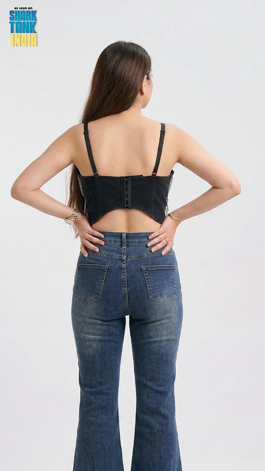 Woman wearing a black denim top and blue jeans on a white background