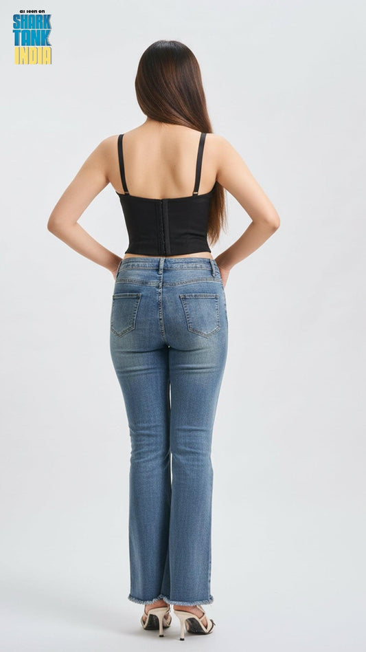 Woman wearing a black top and blue jeans from the back on a white background