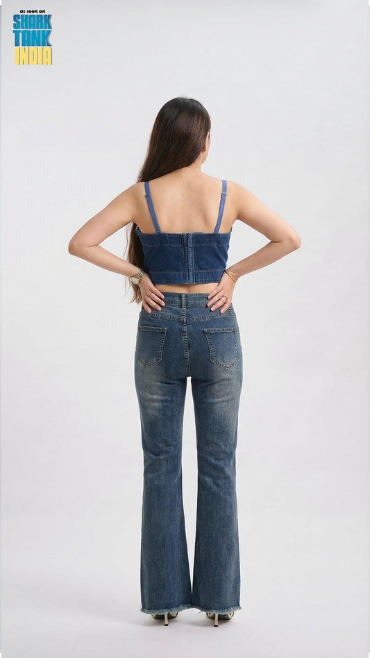 Woman wearing a denim outfit with a crop top and flared jeans on a white background