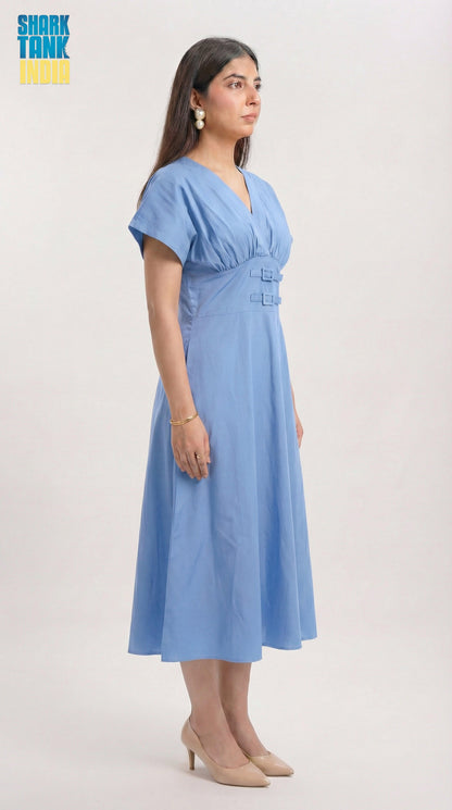 Woman wearing a blue dress on a plain background with 'Shark Tank India' logo.