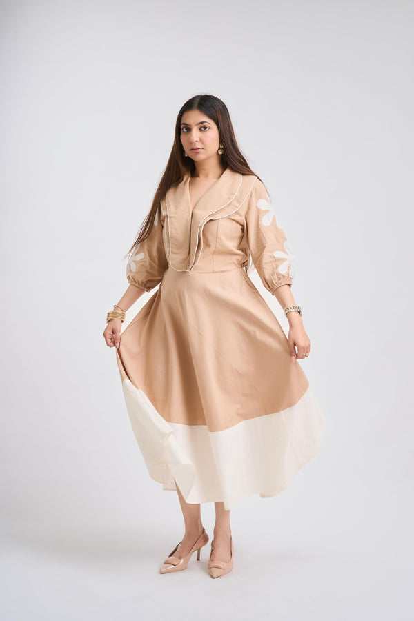 Woman wearing a beige and white dress on a white background