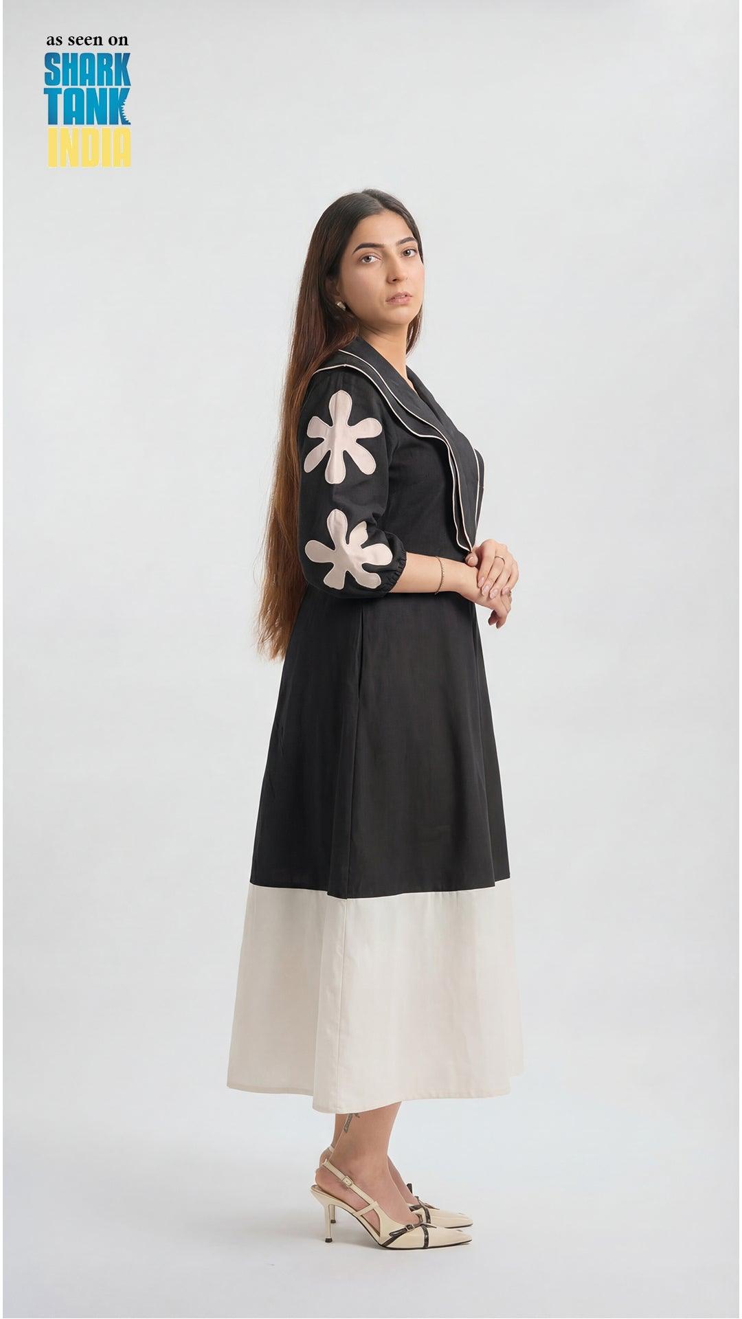 Woman wearing a black dress with white floral patterns on a white background
