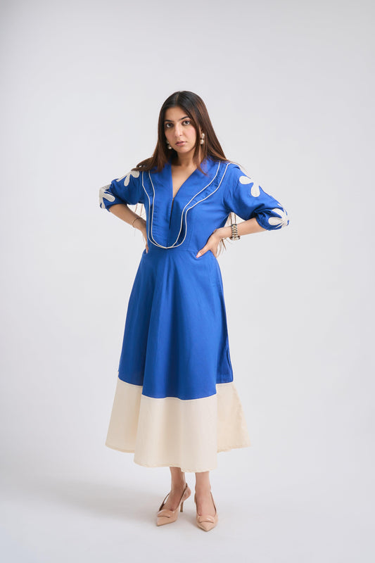 Woman wearing a blue dress with white accents on a white background