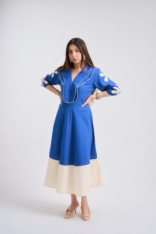 Woman wearing a blue dress with white accents on a white background