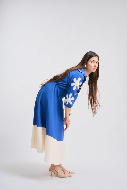 Woman wearing a blue dress with white floral patterns on a white background