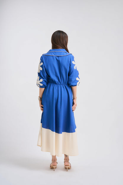Woman wearing a blue dress with white floral patterns on a white background