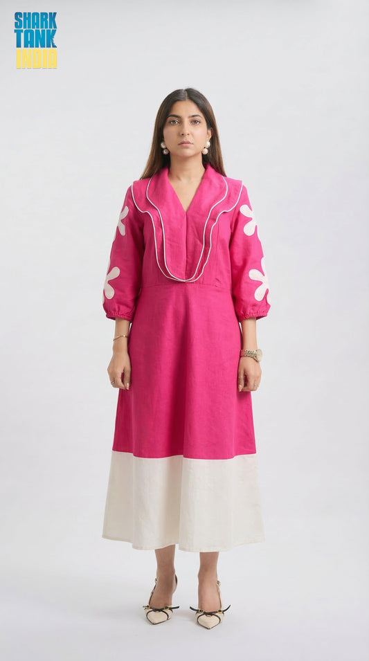 Woman wearing a pink dress with white patterns on a white background