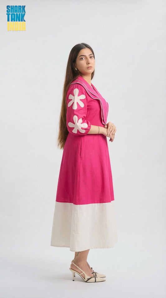 Woman wearing a pink dress with white floral patterns on a white background