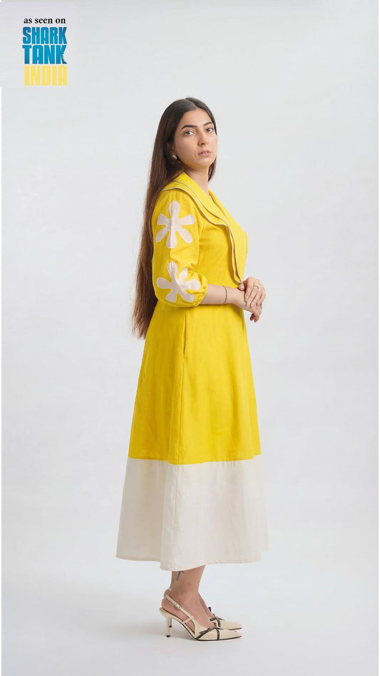 Woman wearing a yellow dress with white floral patterns on a white background