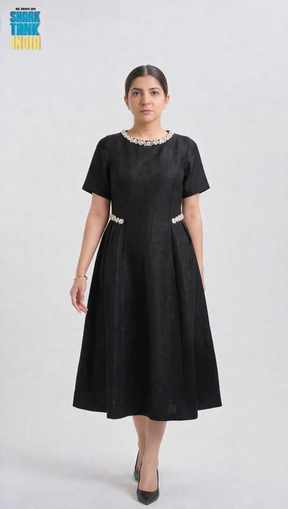 Woman wearing a black dress with white embellishments on a white background