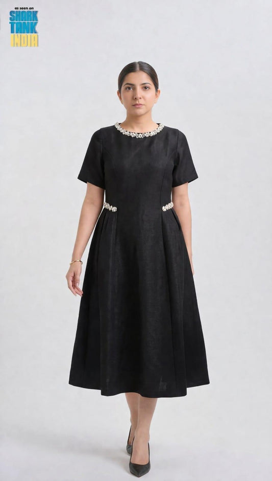 Woman wearing a black dress with white embellishments on a white background