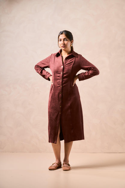 Woman wearing a burgundy dress against a beige background