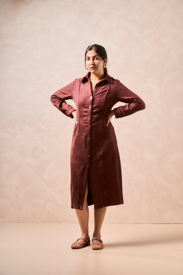 Woman wearing a burgundy dress against a beige background