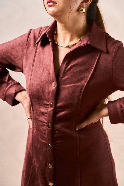 Person wearing a burgundy button-up dress against a neutral background