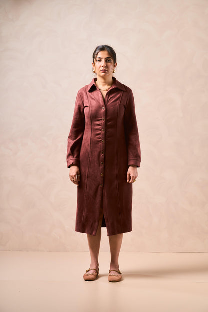 Woman wearing a brown dress against a beige background