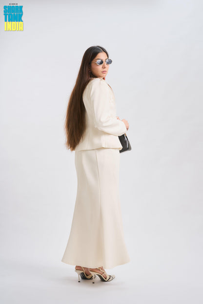 Woman in a white suit standing against a white background
