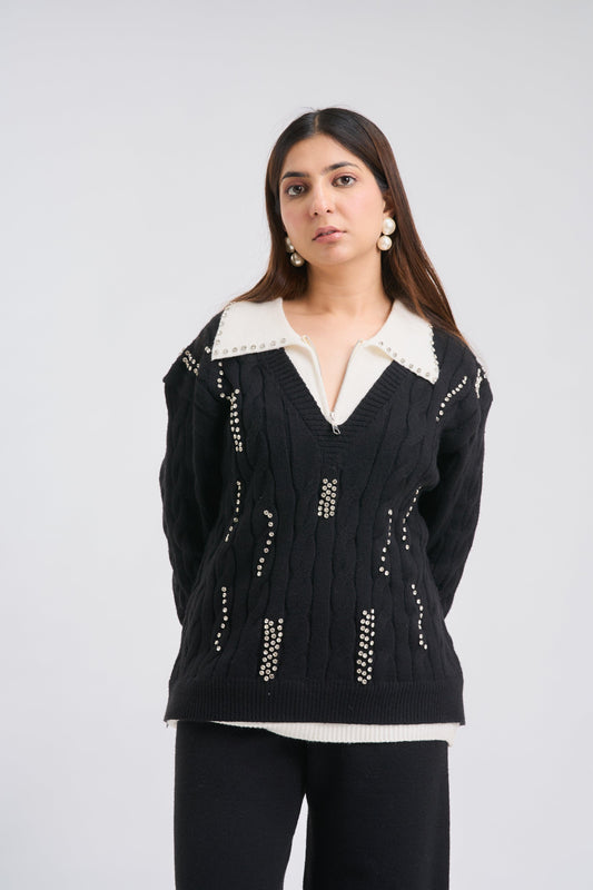 Woman wearing a black sweater with white accents on a plain background