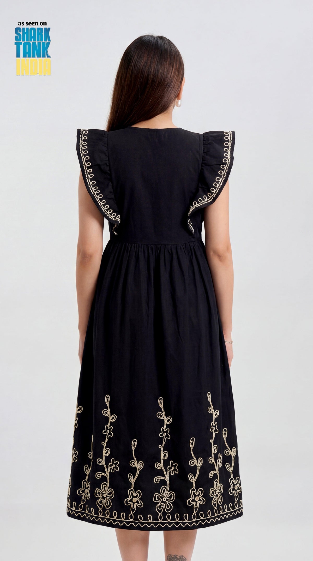 Black dress with floral embroidery on a plain background