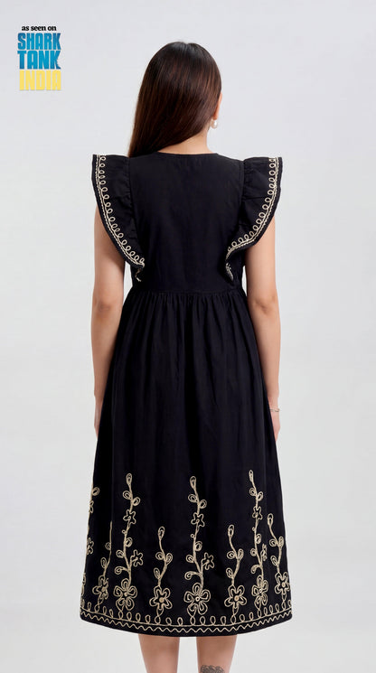 Black dress with floral embroidery on a plain background