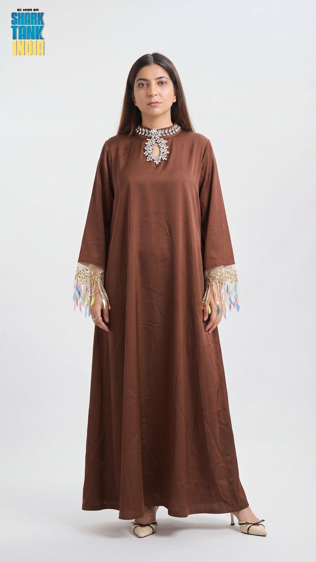 Woman wearing a brown dress with intricate detailing on a white background