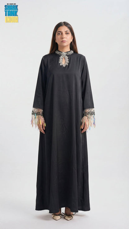 Woman wearing a black dress with embroidery on a white background